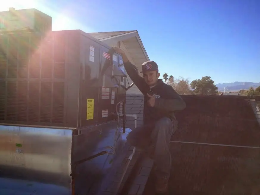 HVAC technician performing Boiler Repair on a rooftop unit in Spanish Fork